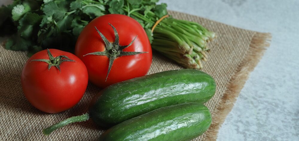 Tomatoes, cucumbers and parsley on brown cloth