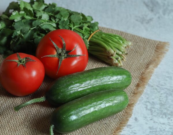 Tomatoes, cucumbers and parsley on brown cloth
